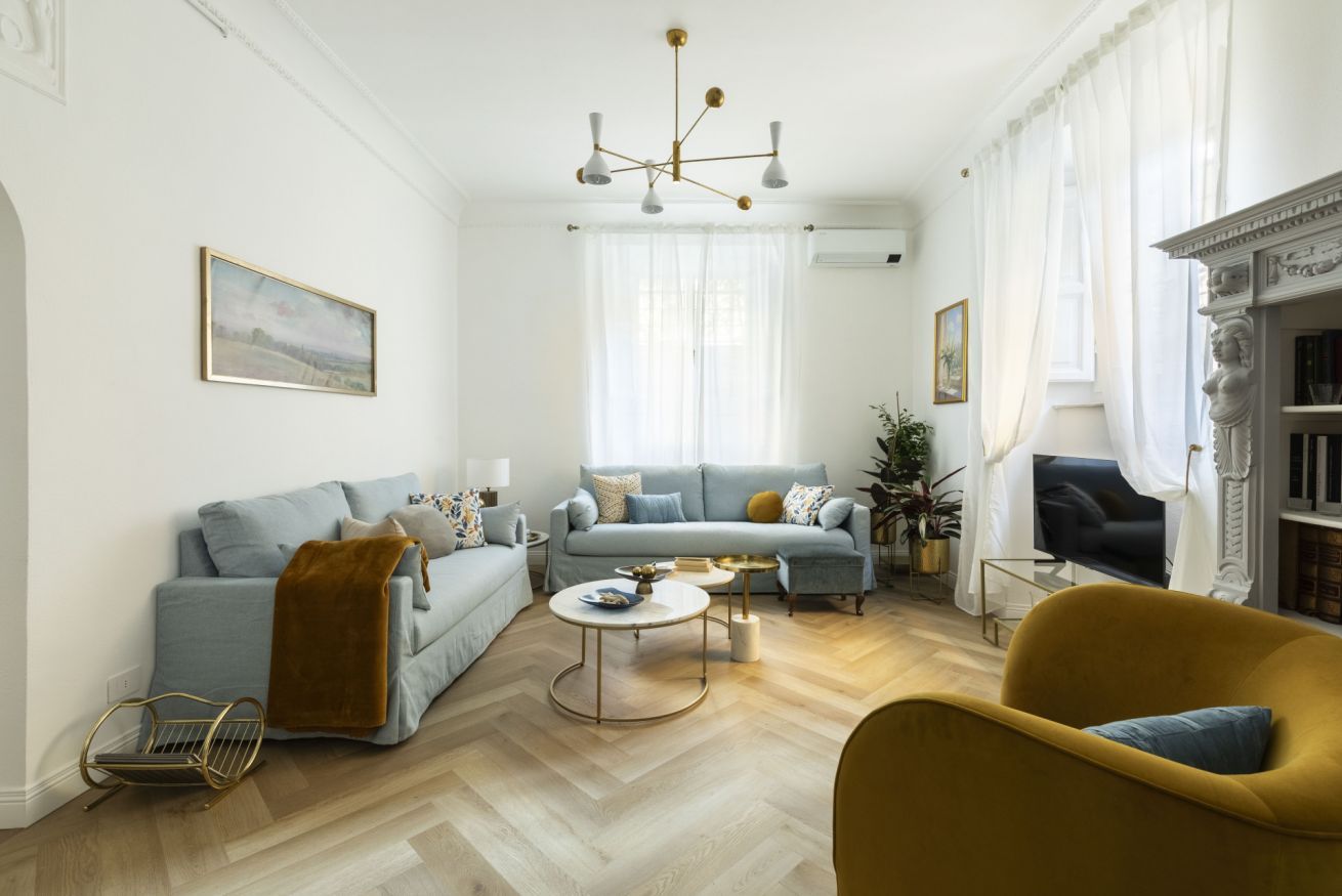 A living room with a sofa, armchairs, a coffee table, and a fireplace.