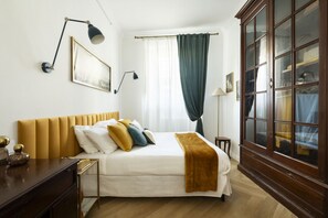Ein ordentlich eingerichtetes Schlafzimmer mit einem Bett, Nachttischen, einem Kleiderschrank und einem Fenster mit Vorhängen.