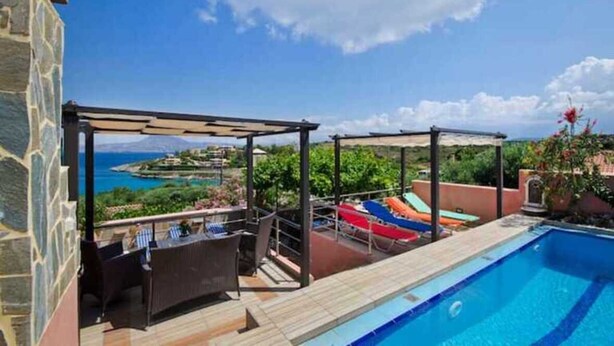 A rooftop pool area with a view of the sea, a covered seating area, and a stone building. - Villa Smaro With Private Pool (Chania)