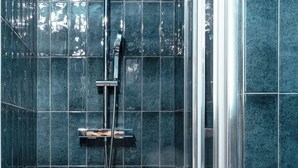 Ein Duschbereich mit einer verglasten Dusche und einem weißen Waschbecken.