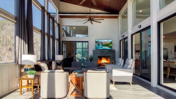 A spacious living area with a fireplace, comfortable seating, and large windows. - Summit Trails Retreat – Indoor Pool, Home Theater, Hot Tub | Sleeps 16!!! (Sevierville)