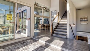A spacious interior with a staircase, large windows, and a dining area. - Summit Trails Retreat – Indoor Pool, Home Theater, Hot Tub | Sleeps 16!!! (Sevierville)