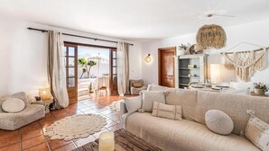 A cozy living room with a sofa, a coffee table, and a fireplace. There is a door leading to a balcony. - Casa del Mar. Spectacular villa with sea views and jacuzzi in Charco del Palo (Chraco del Palo - Haría)