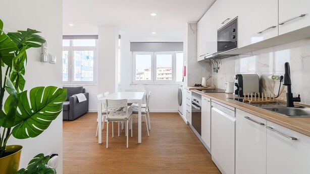 A modern kitchen with white cabinets, a microwave, and a coffee machine. - Apartment 'M J House' with Sea View, Wi-Fi and Air Conditioning (Setúbal)