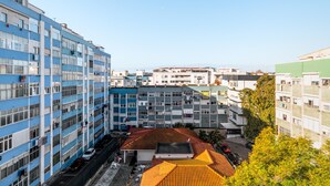 A multi-story building with a parking area in front. - Apartment 'M J House' with Sea View, Wi-Fi and Air Conditioning (Setúbal)