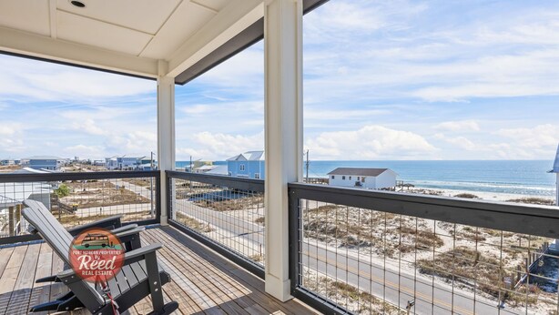 Een overdekt balkon met uitzicht op het strand en de zee.