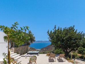 Eine Terrasse mit Sitzgelegenheiten im Freien, einem Whirlpool und Meerblick.