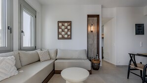 A modern living room with a sectional sofa, a round coffee table, and a wall-mounted light fixture.