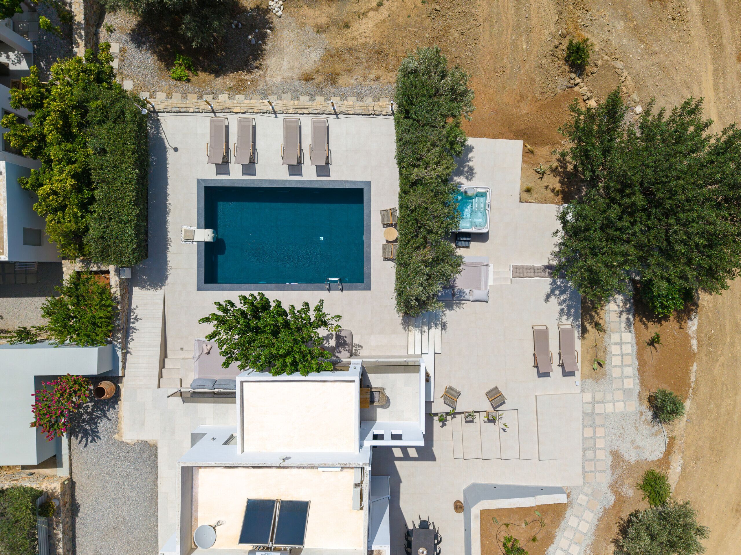 Eine Luftaufnahme eines Wohnhauses mit Swimmingpool, Sitzgelegenheit im Freien und einem Garten.