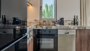 Una cucina moderna con forno integrato, lavastoviglie e una finestra vista alberi.