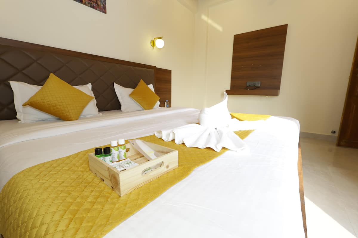 Una habitación de hotel con una cama grande, un cabecero de madera y una mesita de noche con artículos de aseo.