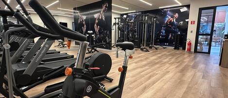 Un gimnasio con cintas de correr, una bicicleta estática y máquinas de pesas.