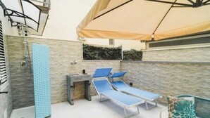 A sunlit outdoor area with a pool table, lounge chairs, and a covered seating area. - Euterpe Apartment - Harmony, Relaxation and Sea at the Abode of the Muses (Praia a Mare)
