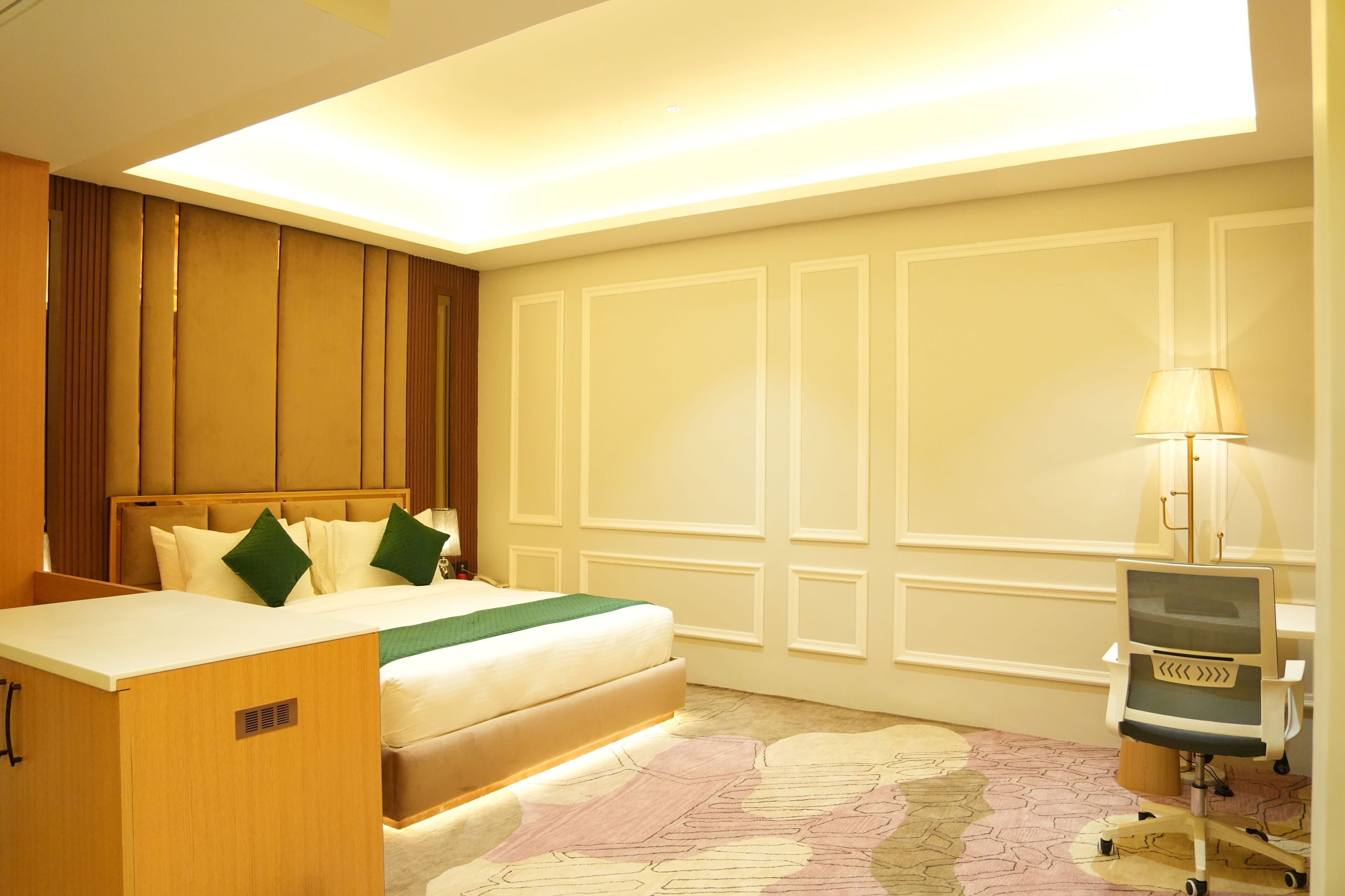 A hotel room with a bed, a desk, and a chair.