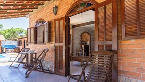 A brick building with wooden shutters and a pool area.
