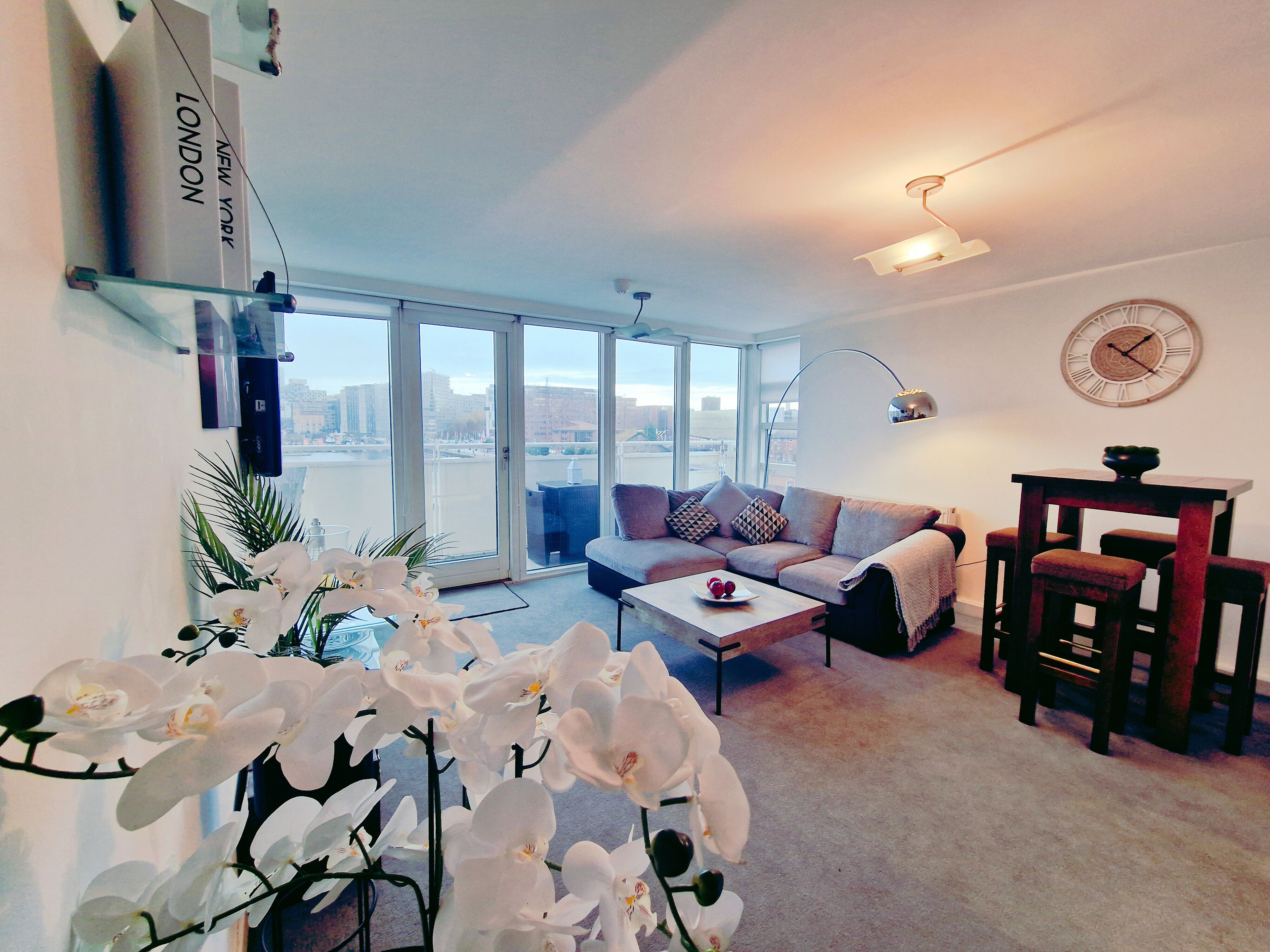 A modern living room with a sofa, coffee table, and a dining area with chairs.