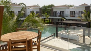 Un hôtel moderne doté d’une piscine, de meubles en bois et d’une rambarde en verre.