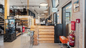A reception area with a wooden log display, a reception desk, and a fire extinguisher. - Hotel Gerhardhof by ami (Wildermieming)