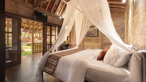 A bedroom with a canopy bed, wooden flooring, and a view of an outdoor area. - Artropeace Ubud Retreat & Villas (Ubud)