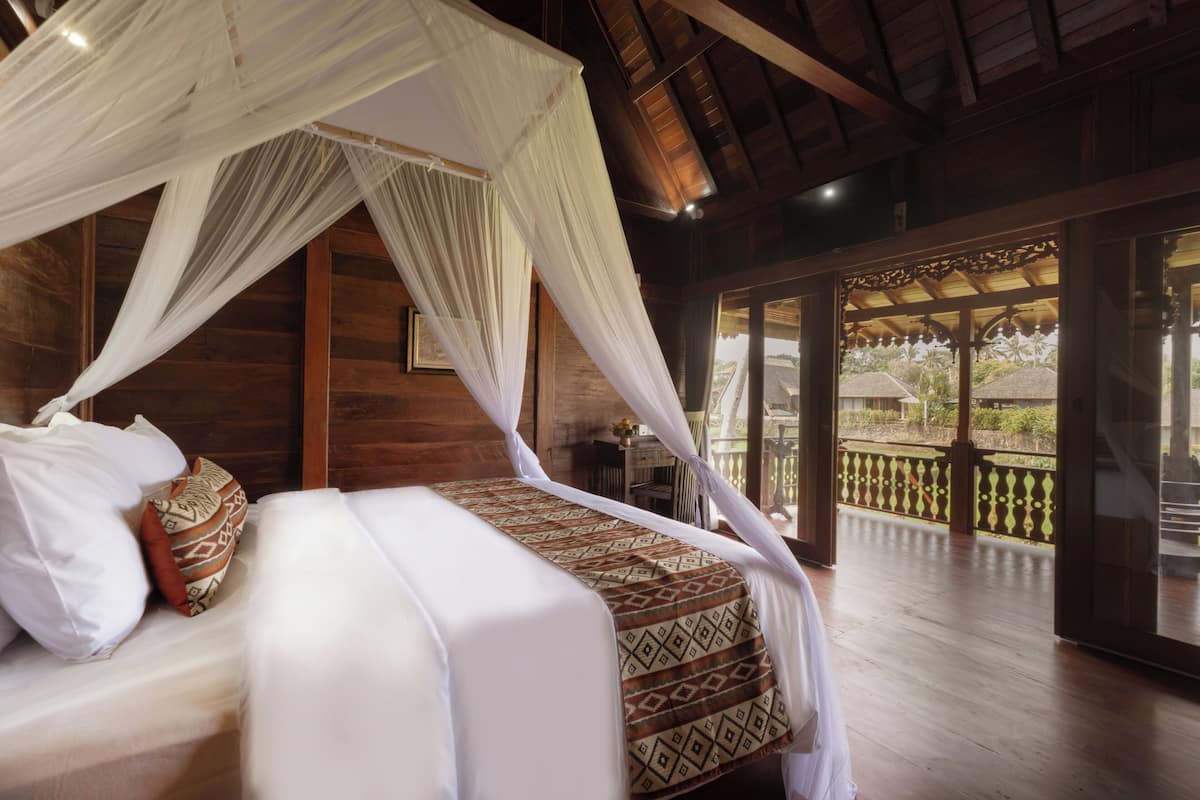 Ein Schlafzimmer mit Baldachinbett, Holzwänden und einem Balkon mit Geländer.