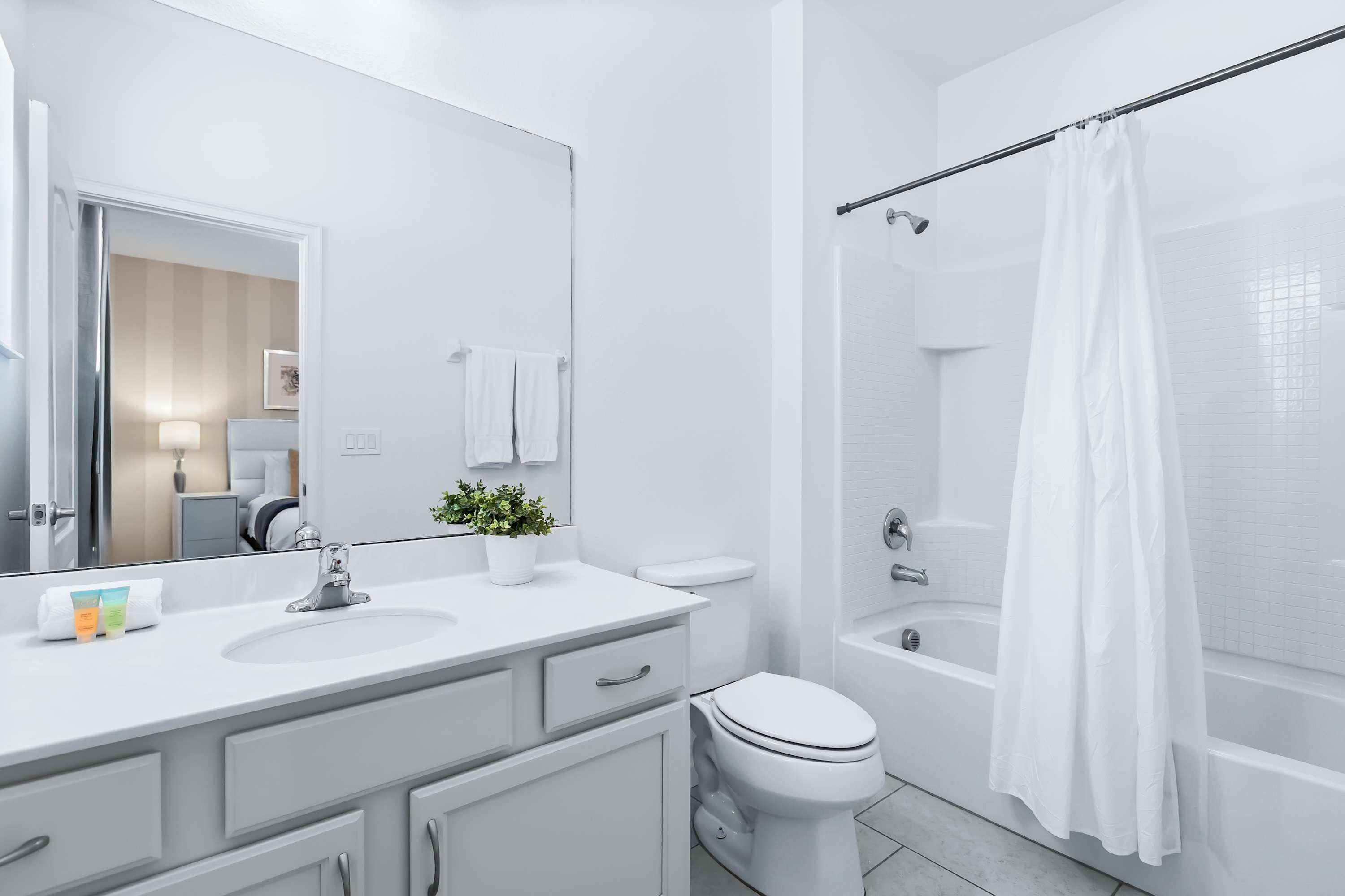 A modern bathroom with a white sink, toilet, and bathtub.