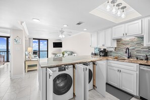 A modern kitchen with built-in appliances, a large island, and a view of the ocean. - Oceanfront-Waterpointe 1 Unit 702-Windy Hill Beach-Sleeps 6-3br/2ba-Pools (North Myrtle Beach)
