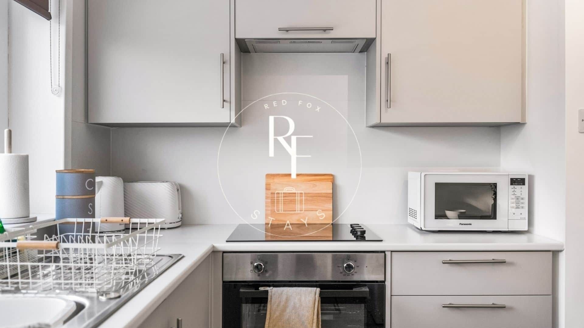 Eine moderne Küche mit Mikrowelle, Backofen und Schneidebrett mit Koffer-Design.