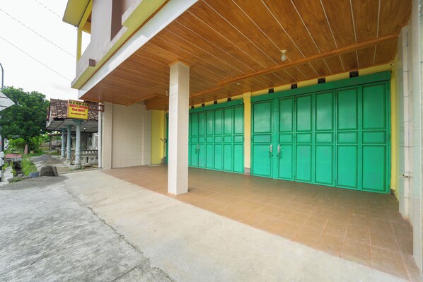 A building with a covered entrance, green doors, and a signboard. - Berkah Guest House Prambanan By ARBA (Ngemplak)