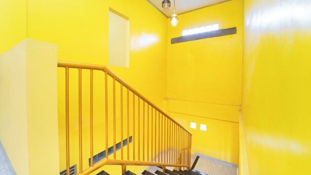 Una escalera con paredes amarillas y barandilla de madera.