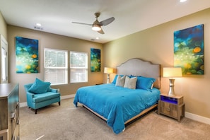 A bedroom with a large bed, two bedside tables, a ceiling fan, and artwork on the walls. - Pool Table & Fenced Yard: Home 5 Mi to NRG Stadium (Houston)