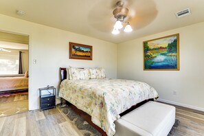 A bedroom with a bed, a nightstand, a bench, and two paintings on the walls. - Family Home w/ Games & Fenced Yard in San Antonio! (San Antonio)