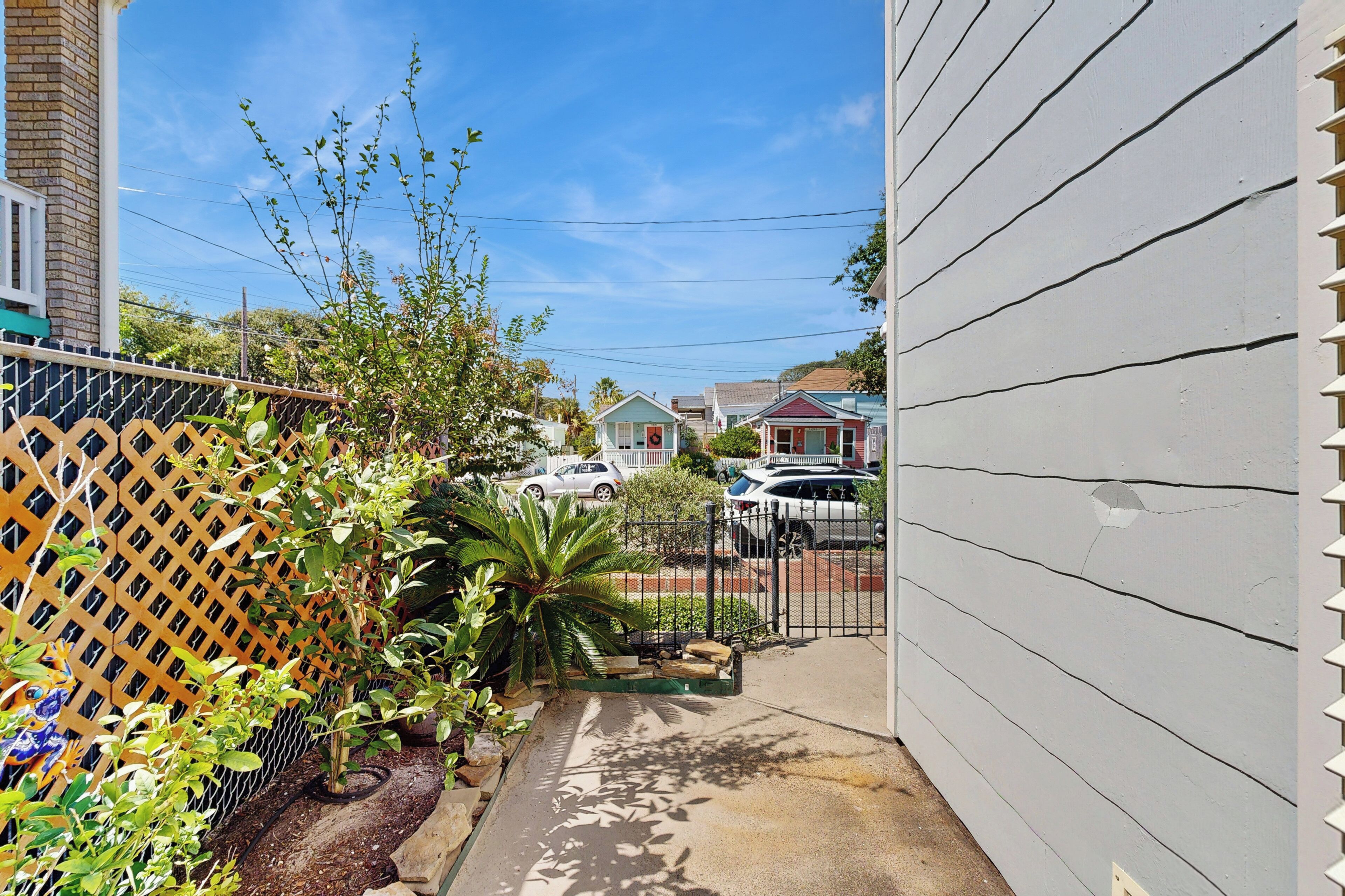 A residential street with houses, a fence, and a sidewalk.