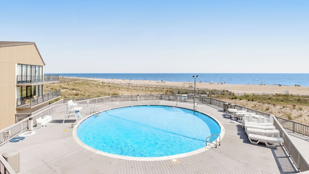 Een zwembad met uitzicht op het strand en de oceaan.
