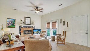 A spacious living room with a fireplace, television, and comfortable seating. - 3 BR Home, Private Pool, Close to Event Venues (La Quinta)