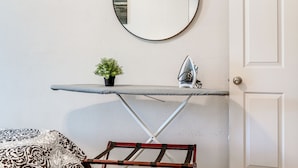A room with a wall-mounted ironing board, a small potted plant, and a door. - 9 Mi to Rangers & Cowboys Home Games: DFW Studio (Grand Prairie)
