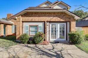 A two-story house with a brick facade, a garage door, and a front porch. - 9 Mi to Rangers & Cowboys Home Games: DFW Studio (Grand Prairie)