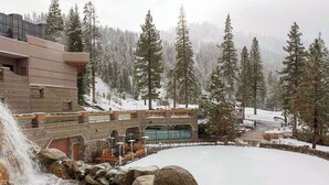 A hotel with a stone facade, a pool, and a waterfall. - Everline Resort Suite: North Lake Tahoe Luxury! (Olympic Valley)