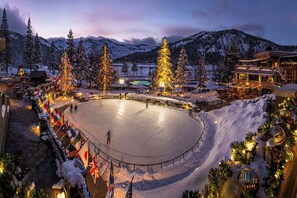 An outdoor ice skating rink surrounded by snow-covered trees and mountains. - 2BR Condo w/ Pool Access, Hot Tub, & ski In/out (Olympic Valley)