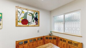 Une pièce comprenant un banc en bois, un vitrail et une œuvre d’art accrochée au mur.