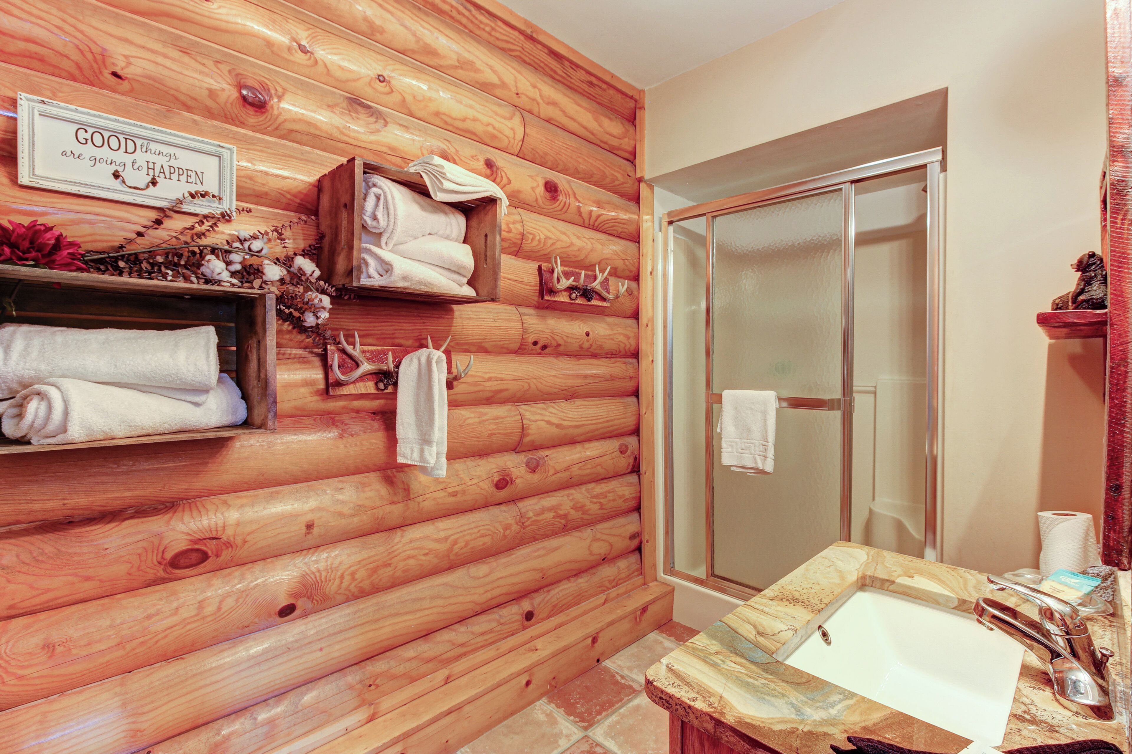 Un bagno con pareti in legno, un lavandino e una doccia.