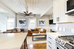 A modern kitchen with a central island, white cabinetry, and a built-in stove. - Private Hot Tub & Sauna! Midway Family Hideaway (Midway)