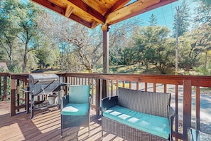 A wooden deck with a grill, two chairs, and a wicker sofa. - 4BR Home Near Yosemite w/ Pool Table (Groveland)