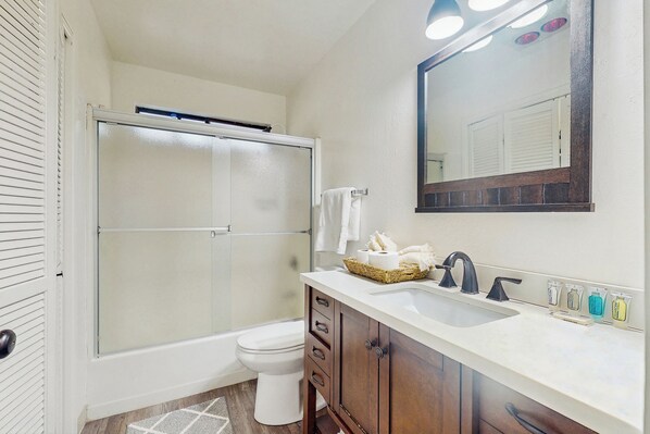 A bathroom with a shower, toilet, sink, and mirror. - 4BR Home Near Yosemite w/ Pool Table (Groveland)