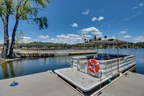 Un bateau amarré, avec un panneau indiquant «service de navette fluviale», une bouée de sauvetage et une vue dégagée sur l’eau et le ciel.