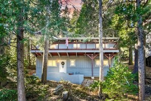 A cabin with a wooden deck, surrounded by trees. - Idyllic Cabin in the Woods: Cozy Crestline Retreat (Crestline)