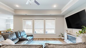 Un salon moderne avec un canapé en cuir, un téléviseur à écran plat et une cheminée.