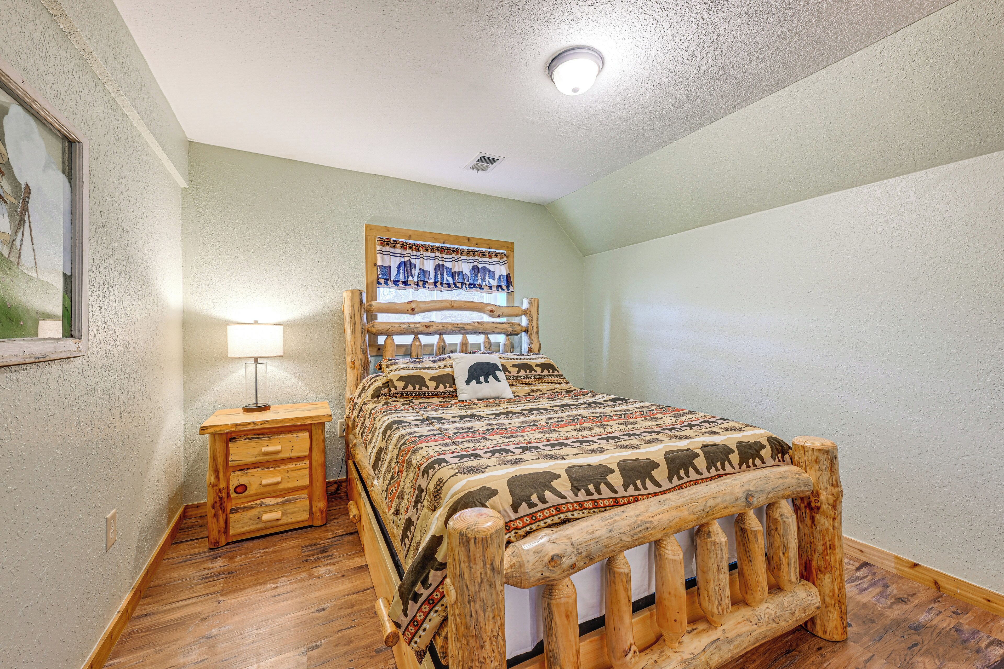 A wooden bed with a headboard, a bedside table, and a lamp.