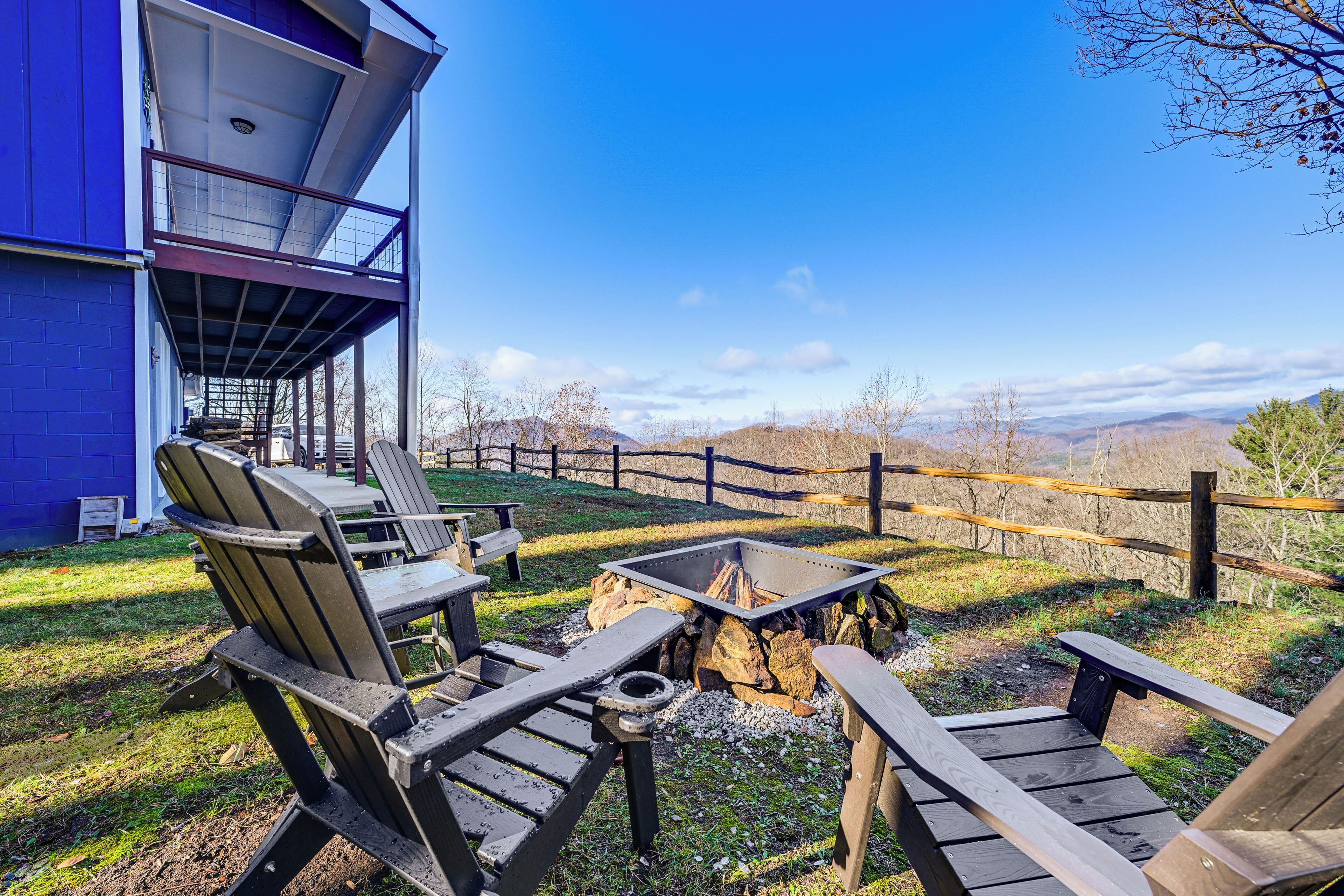 Une terrasse avec des sièges extérieurs et un foyer, offrant une vue sur un paysage montagneux.