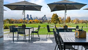 An outdoor patio with two large umbrellas, a table, and chairs. - New Listing! Walk to City Park & Restaurants |  Extended Stays | Central AC (Denver)