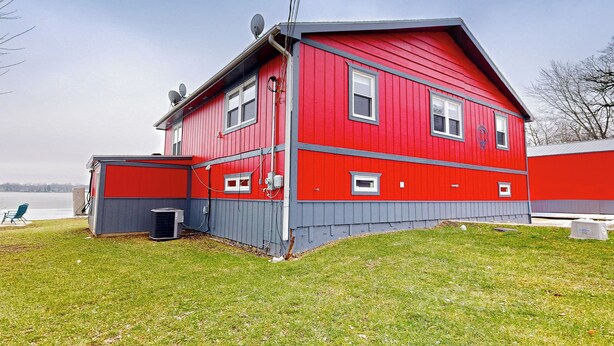 Un edificio de color rojo y gris con varias ventanas y una antena parabólica.